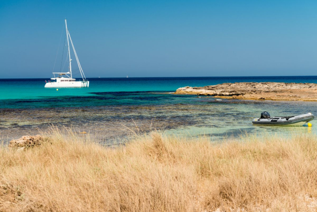 Aguas turquesas y arena blanca en Ses Illetes, Formentera, parada esencial desde Ibiza en velero
