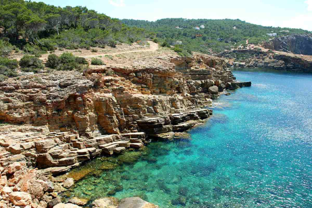 Formaciones rocosas planas de Punta Galera con personas sentadas observando la puesta de sol.