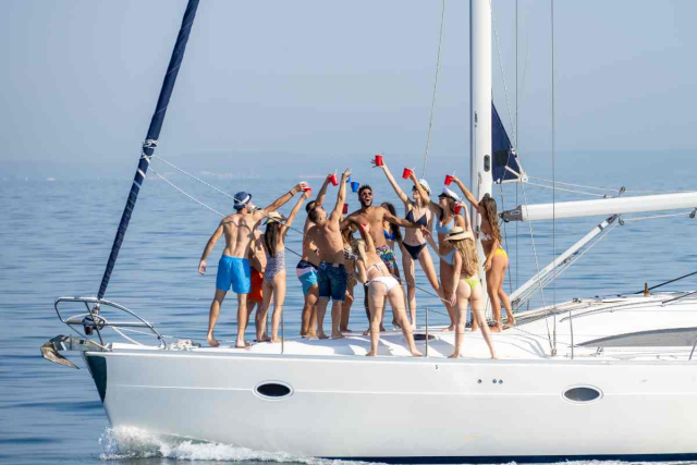  Invitados de boda disfrutando de un cóctel al atardecer en un barco en Ibiza