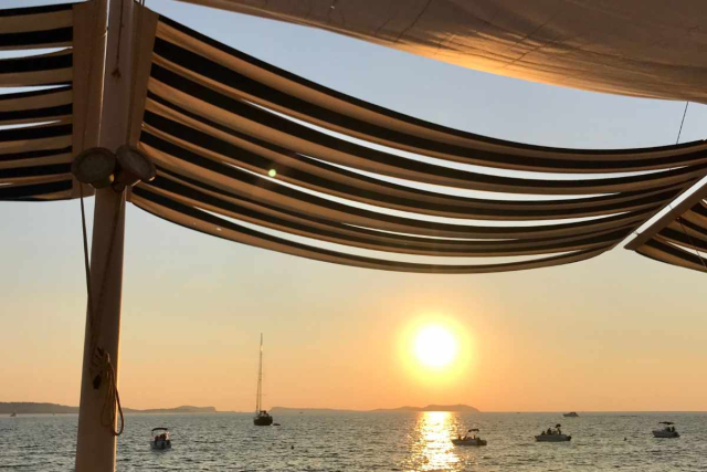 Amanecer en Ibiza desde una cala tranquila con cielo rosado y mar Mediterráneo